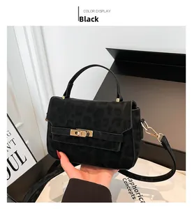 Close-up of black leopard print Kelly bag with golden twist lock and top handle