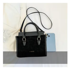 Dettagli della borsa nera minimalista con scritta dorata e tracolla rimovibile