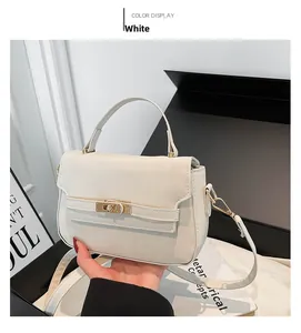 Detail view of white French style Kelly handbag with golden turn-lock and leather texture