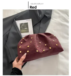 Dettaglio borsa a mano rossa con borchie dorate e pelle con trama leopardata a rilievo