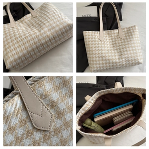 Detail view of large woven houndstooth tote bag with leather handles and spacious interior
