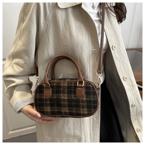 Dettaglio della trama a quadri vintage e tracolla in pelle di una borsa elegante