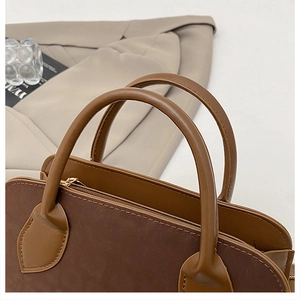 Dettaglio borsa tote marrone scuro con texture scamosciata opaca e cerniera dorata
