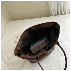 Top view of spacious brown woven tote bag showing internal storage for tablets and books