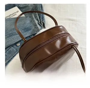 Macro detail of brown glossy PU leather shoulder bag with zipper and white fluffy charm