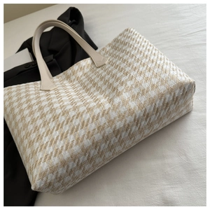 Detailed close-up of woven herringbone pattern and premium leather handle on tote bag