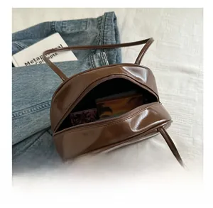 Detail view of brown glossy PU leather bag capacity with internal storage items