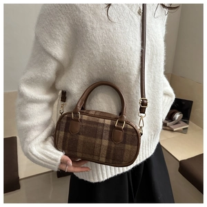 Dettaglio della borsa a cuscino vintage a quadri con manici in pelle e dettagli dorati