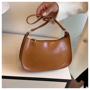 Close-up of vintage brown underarm bag with pleated leather texture and gold hardware