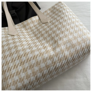 Detail of herringbone woven tote bag showing premium texture and leather handles