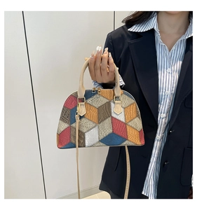 Detail of color-block geometric tote bag with gold hardware and leather texture