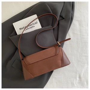Detail of brown vintage baguette bag showing suede texture and adjustable shoulder strap