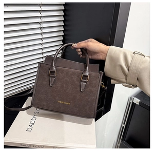 Dettaglio borsa a mano marrone vintage con trama marmorizzata e scritta Fashion Bags
