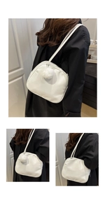 White glossy leather pillow bag with cute plush pom-pom showing single shoulder wear effect