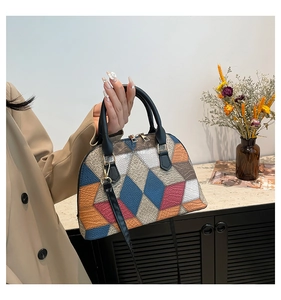 Detail of color-block shell handbag with checkered pattern and gold metal hardware