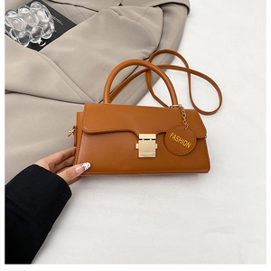 Détail du sac bandoulière en cuir caramel avec boucle dorée et pendentif Fashion