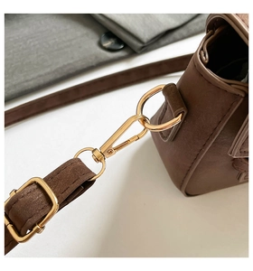 Detail of adjustable brown leather strap with polished light gold metal swivel clasp hook