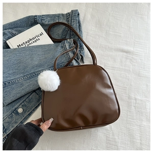 Détail du sac à main marron en cuir PU avec pompon en peluche et fermeture à glissière