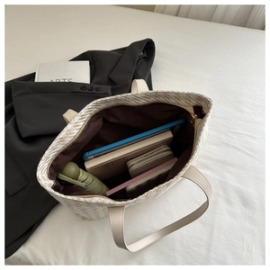 Top view of large woven tote bag interior showing spacious storage for tablet and umbrella