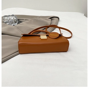 Vue détaillée du sac en similicuir marron avec fermoir doré et étiquette de mode