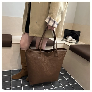 Detailed close-up of brown tote bag featuring premium woven texture and large capacity