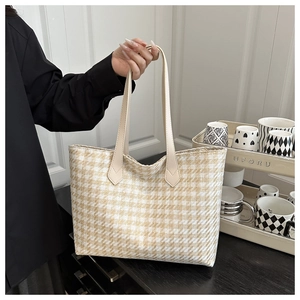 Close-up of yellow and white houndstooth woven tote bag with durable PU shoulder straps