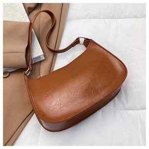 Detail of vintage brown crescent bag in glossy oil wax leather with gold metal buckle