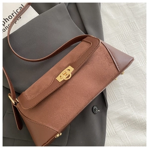 Detail of vintage brown suede leather bag with gold twist lock on grey blazer