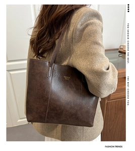 Detailed view of the dark brown tote bag showing natural leather texture and shoulder strap