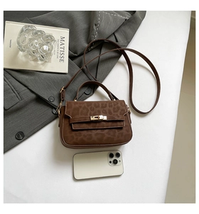 Brown leopard print crossbody bag with golden clasp on grey suit jacket