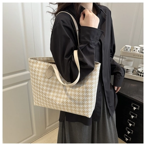 Macro detail of large woven houndstooth tote bag in cream and light yellow with slim strap