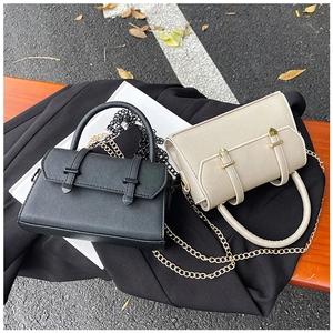 Close-up of black and beige mini crossbody bags with cross-grain texture and metal chains