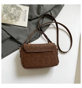Detail of deep brown leopard print handbag with golden hardware buckle and leather texture