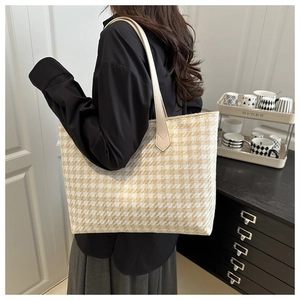Detail of beige houndstooth tote bag with premium leather handles for autumn style