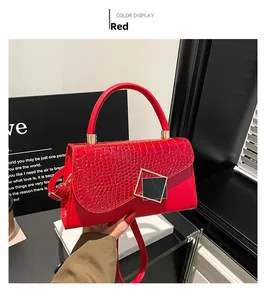 Detail of red stone texture shoulder bag with gold buckle and chain strap