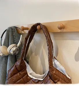 Close-up of caramel brown quilted nylon tote bag with wide reinforced handles
