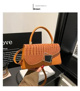 Close-up of brown crocodile texture flap and square metal buckle on small handbag