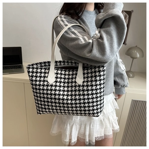 Detail of black and white houndstooth tote bag on model for daily commuting style