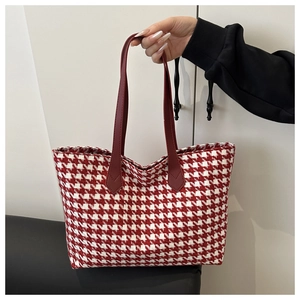 Detail of red and white houndstooth tote bag with leather strap and tweed texture
