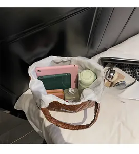 Spacious interior of quilted brown tote bag showing capacity for tablets and wallet