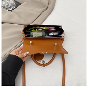 Vue intérieure du sac bandoulière rétro marron montrant sa grande capacité et accessoires