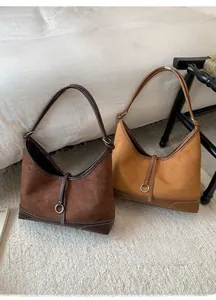 Close-up of retro suede hobo bags in coffee and ginger yellow with smooth leather trim