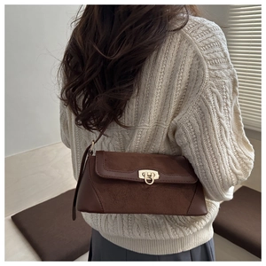 Brown leather shoulder bag with gold twist lock and dual-texture stitching detail