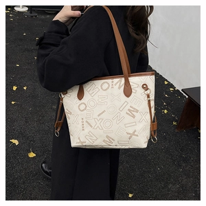 Dettaglio della grande borsa tote con stampa monogramma vintage e manici in pelle marrone