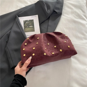 Borsa a nuvola bordeaux con stampa leopardata e borchie dorate su sfondo bianco