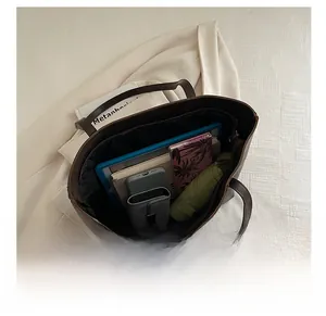 Spacious brown bucket tote bag interior showing capacity for tablet, phone, and umbrella