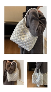 Detail of white quilted nylon tote bag featuring glossy texture and fashion label