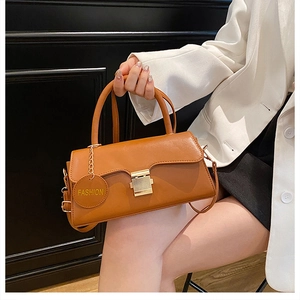 Détail du sac bandoulière vintage marron avec fermoir doré et breloque mode ronde