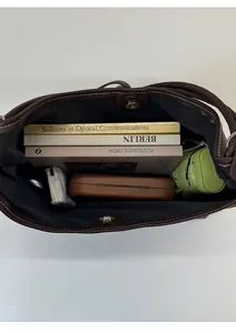 Top view showing spacious interior of brown suede tote bag with daily essentials