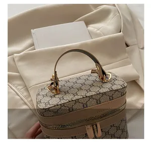 Detail of vintage monogram cosmetic bag with gold hardware on white blazer background